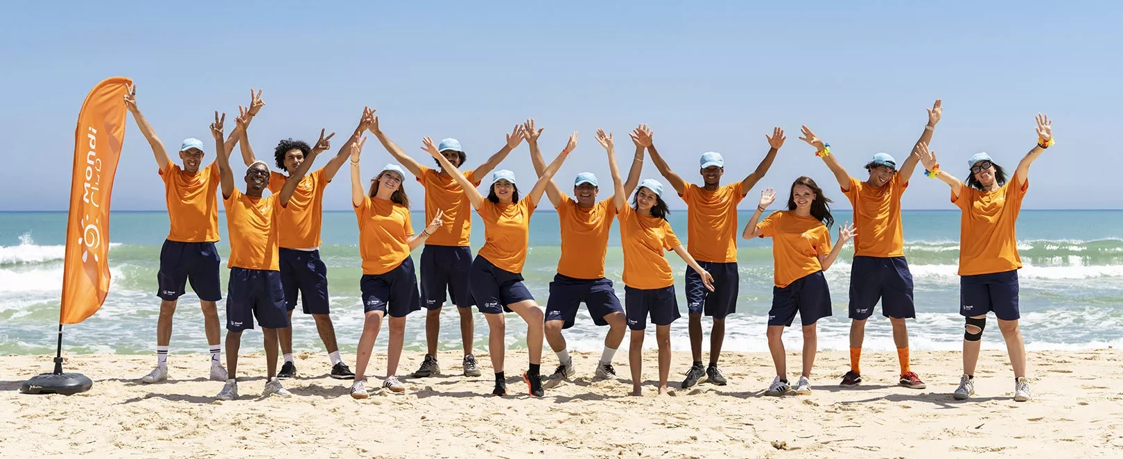 Animateurs en tee shirt orange devant la mer