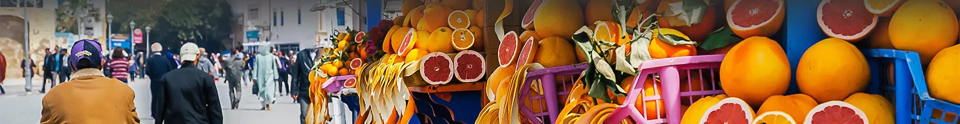 des gens sur la place Jemaa El Fna à Marrackech et un étal d'oranges
