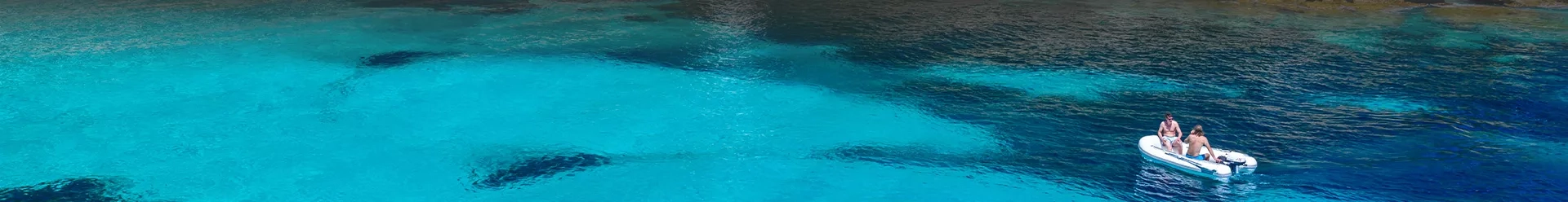 un petit bateau à moteur sur une eau turquoise