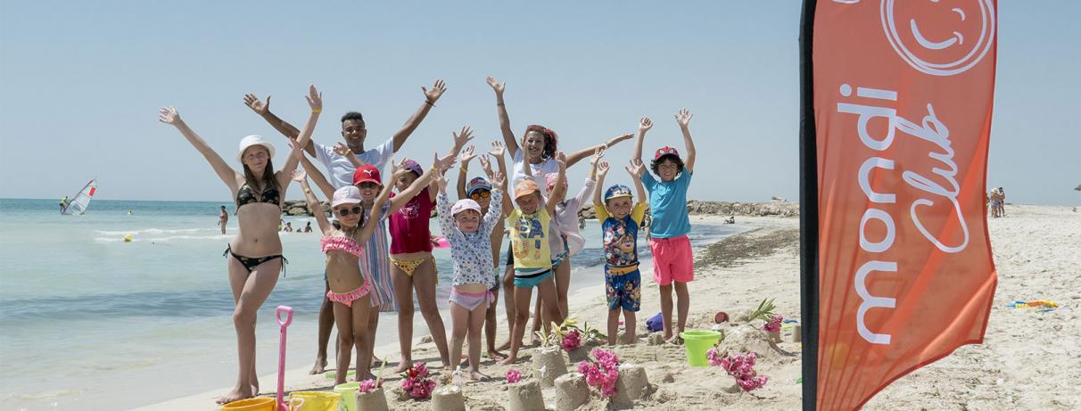 enfants sur la plage avec drapeau Mondi Club