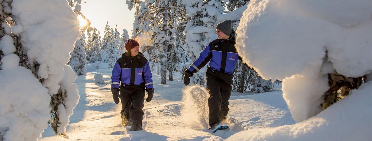 2 personnes marchant dans la neige avec des raquettes