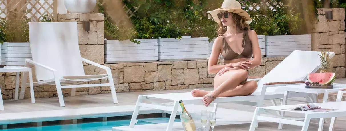 femme avec chapeau au bord de la piscine