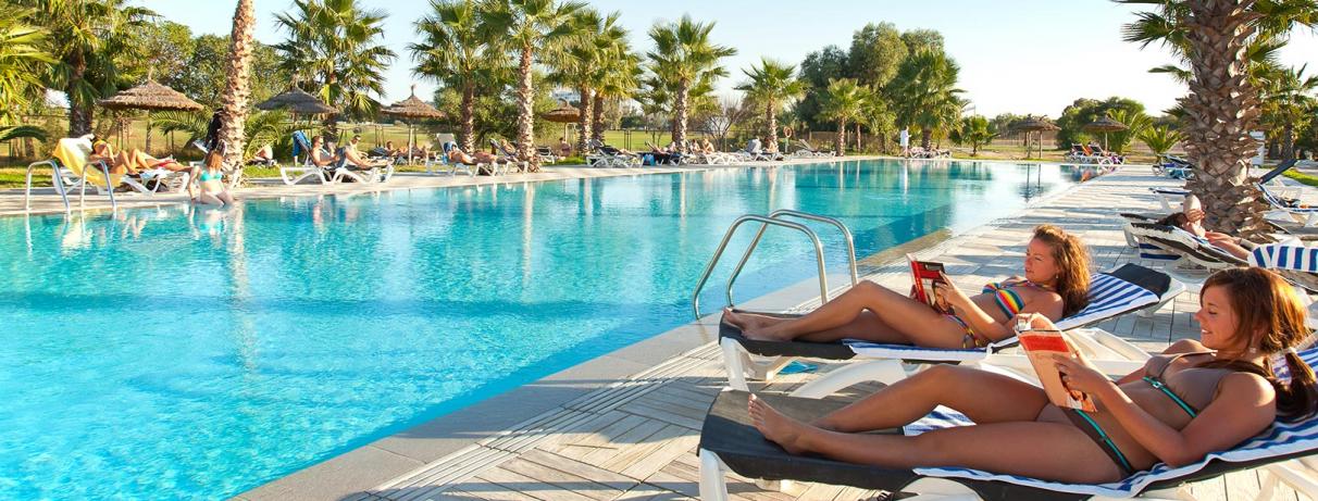 2 femmes sur transats devant piscine