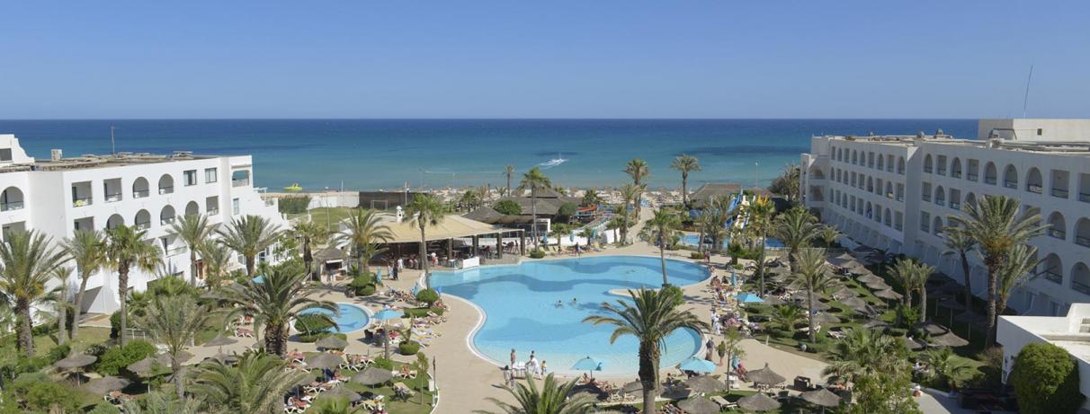 piscine et bâtiment hotel et mer en arrière plan