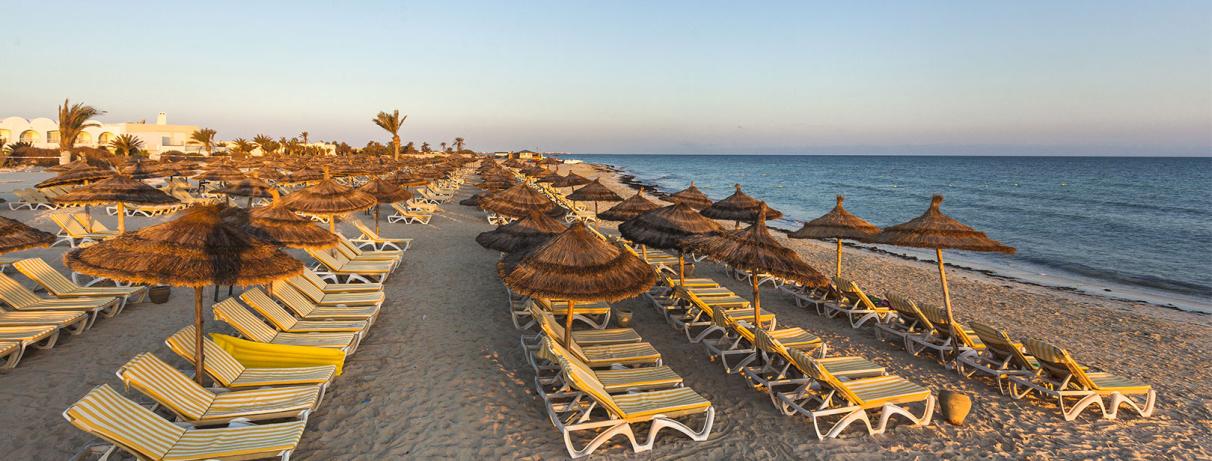 plage avec transats au coucher du soleil