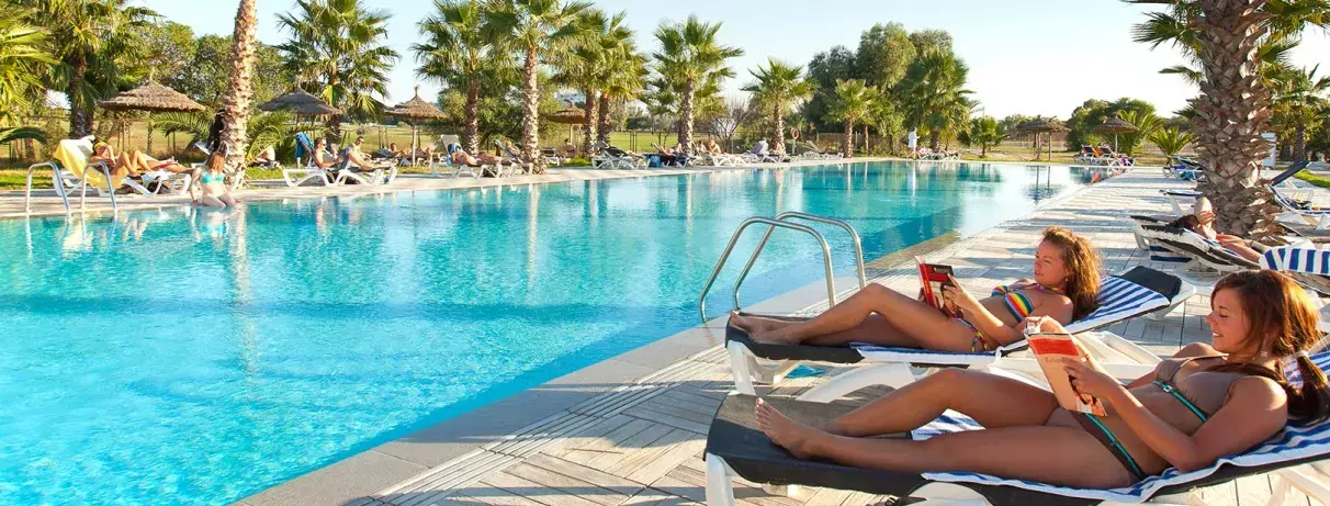2 femmes sur transats devant piscine