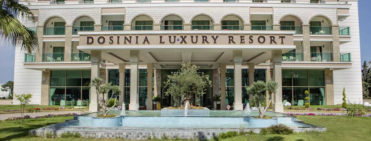 devanture hôtel avec pelouse et petite fontaine à eau