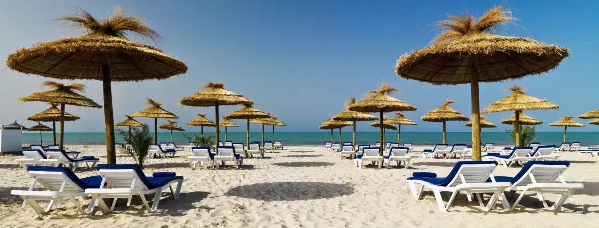 plage palmiers et transats