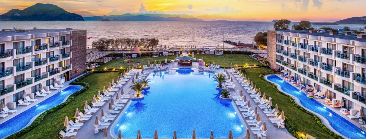 vue d'ensemble de l'hôtel avec piscine et mer avec un coucher de soleil