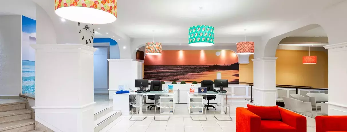 Un hall d'entrée moderne et coloré, mêlant un mobilier rouge vif à un éclairage design.