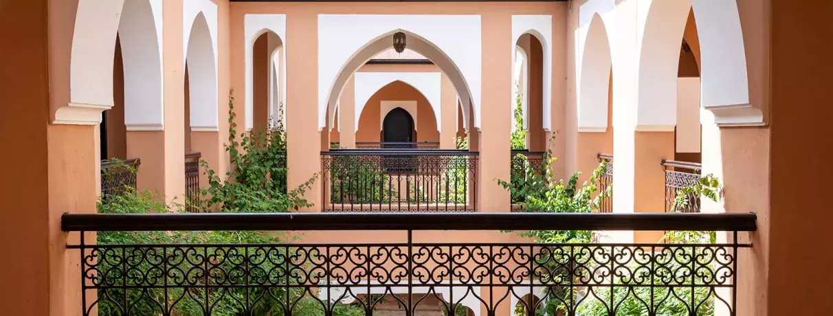 balcon des couloires des chambres avec des arcs, donnant sur le patio