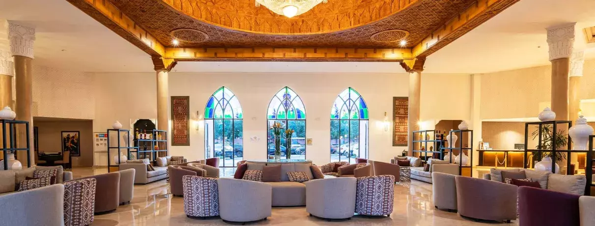 Réception de l'hôtel avec des chaises en beige et un toit sculpté oriental bien décoré