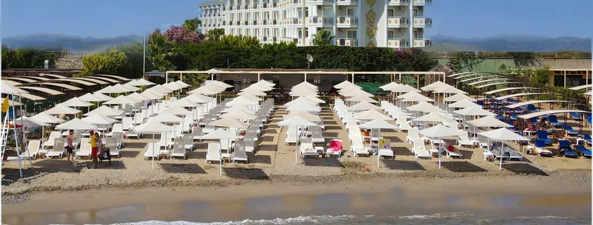 plage  avec le mer et parasols et transats et en fond vue de l'hôtel