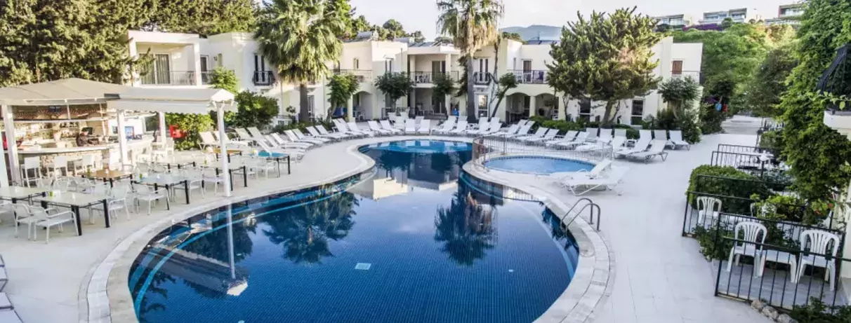 piscine extérieure avec transats et vue sur la façade de l'hôtel