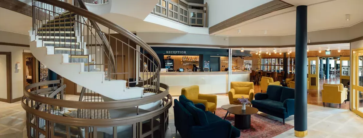 réception avec escaliers, fauteuils et tables