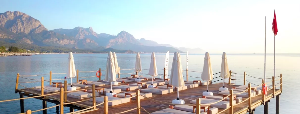 Vue du ponton en bois dans la mer rejoignant la plage et l'hôtel.