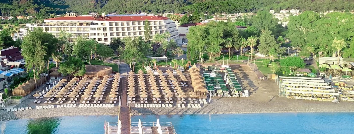 Vue du complexe hôtelier dans la verdure avec la plage en bord.