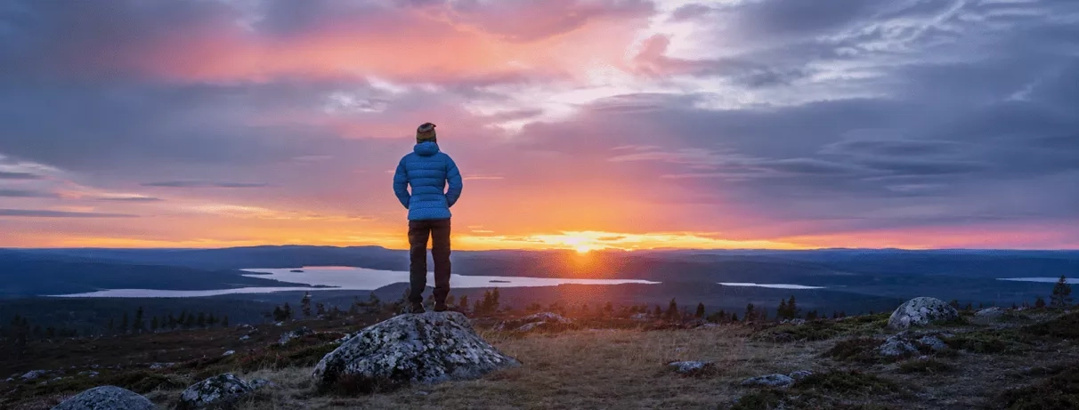 homme contemplant le soleil de minuit à levi en laponie en été 