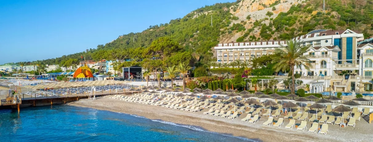 Vue de l'hôtel en bord de plage avec les collines en fond.