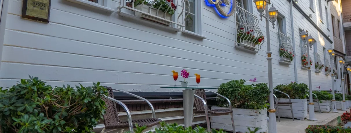 vue de la façade extérieur de l'hôtel avec une table et deux cocktails.