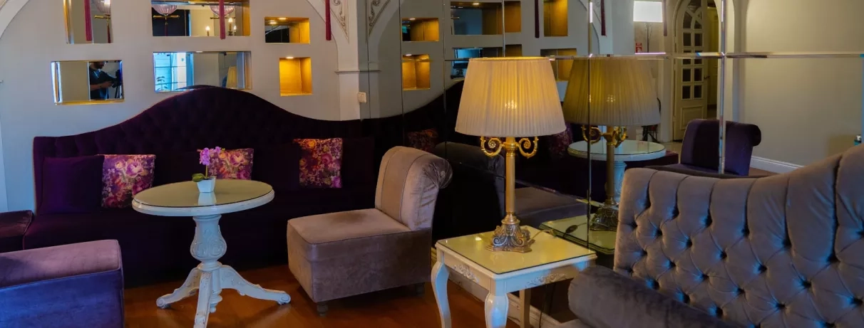 vue du hall d'entrée de l'hôtel avec des canapés, des fauteuils et des lampes.