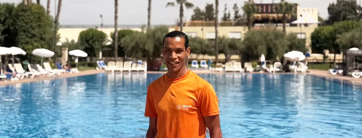 Animateur Mondi Club t shirt orange piscine bleue transate parasol