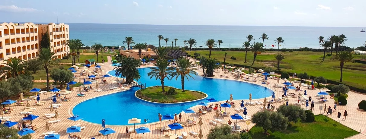 vue aérienne sur le Nour Palace à Mahdia avec piscine plage transats palmiers et batiment