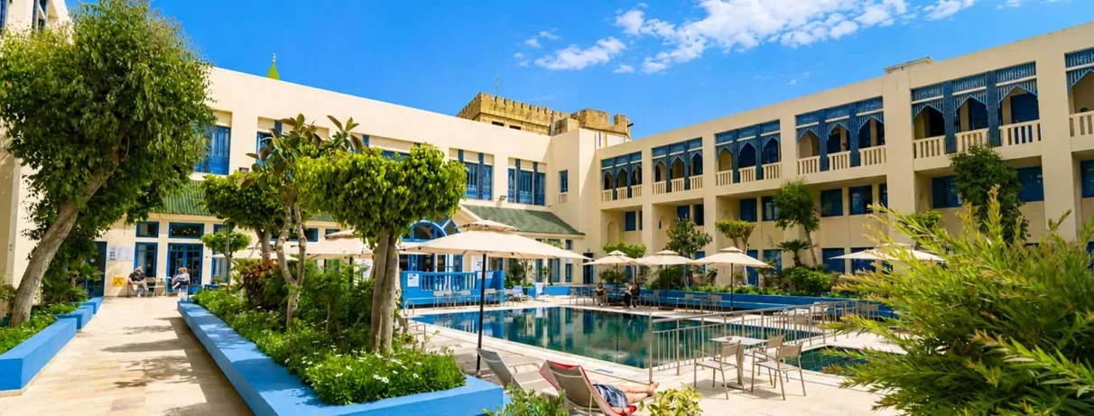 piscine extérieure équipée de transats et bâtiment de l'hôtel