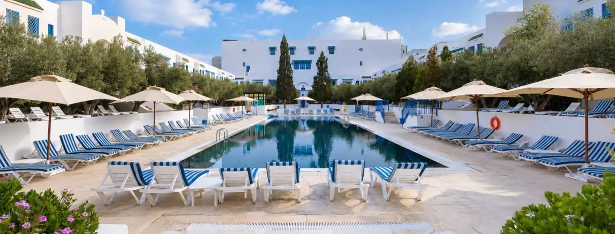 piscine extérieure vue de jour, équipée de transats 