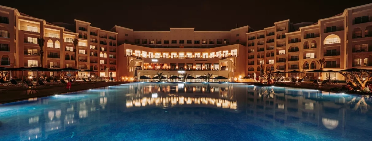 façade hôtel vue de nuit piscine éclairée lumières jaunes