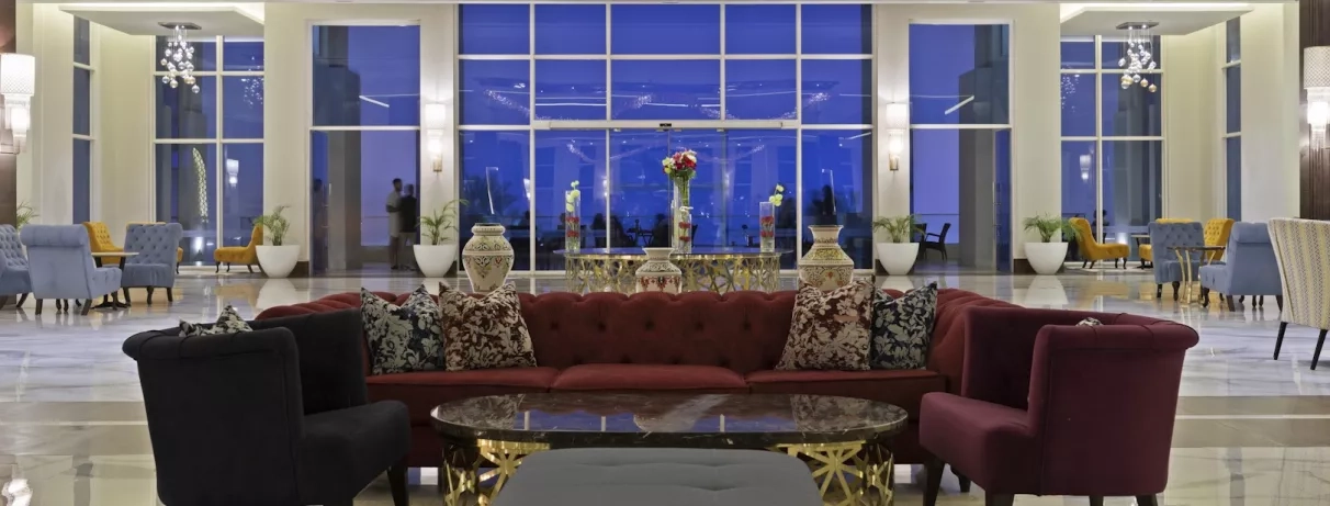 beau canapé rouge coussins baie vitrée nuit tombée vases
