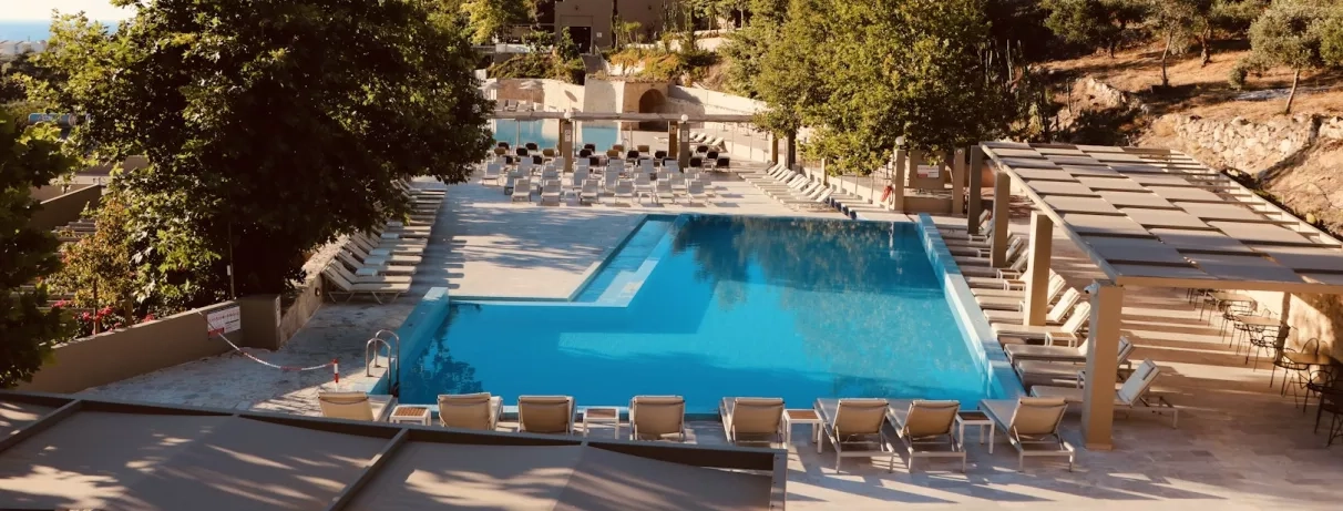 Vue de la piscine extérieur de l'hôtel au milieu du jardin.