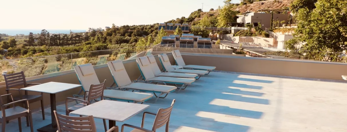 Vue de la terrasse de l'hôtel avec plusieurs transats.