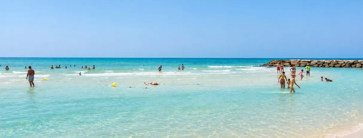 Baignade dans les eaux claires et turquoise de la plage privée du Mondi Club Aladin Djerba en Tunisie.