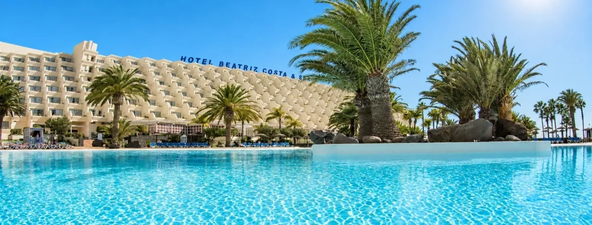Une vue d'ensemble sur la façade de l'hôtel et sa piscine 