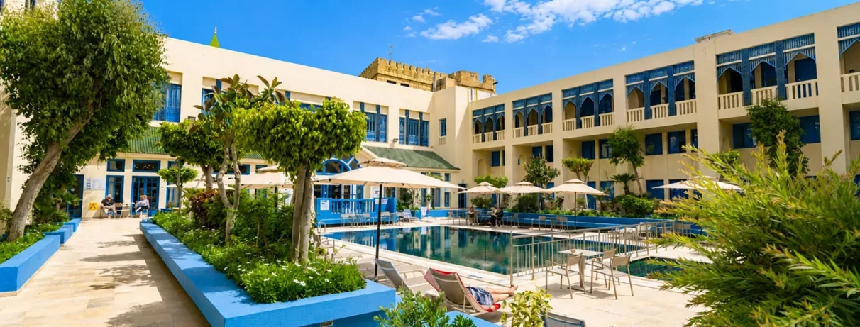 piscine extérieure équipée de transats et bâtiment de l'hôtel