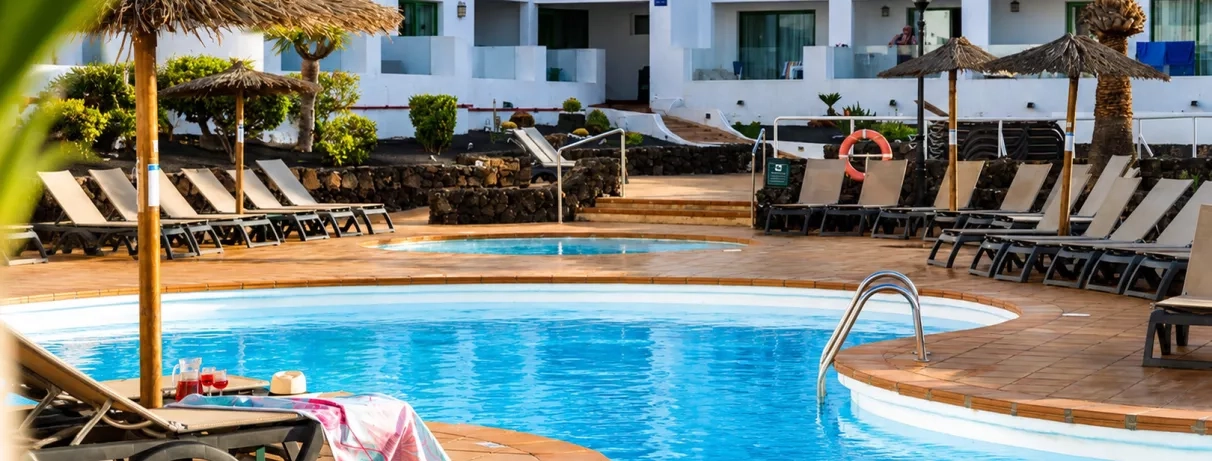 Un plan rapproché sur les rangées de chaises longues installées au bord de l'eau, sous le soleil.