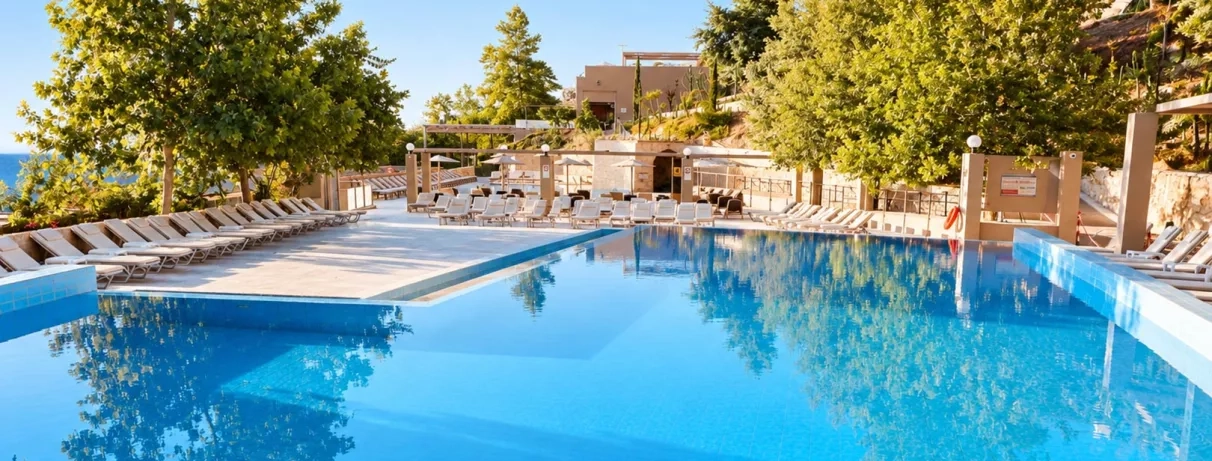 Vue de la piscine extérieur de l'hôtel au milieu du jardin.