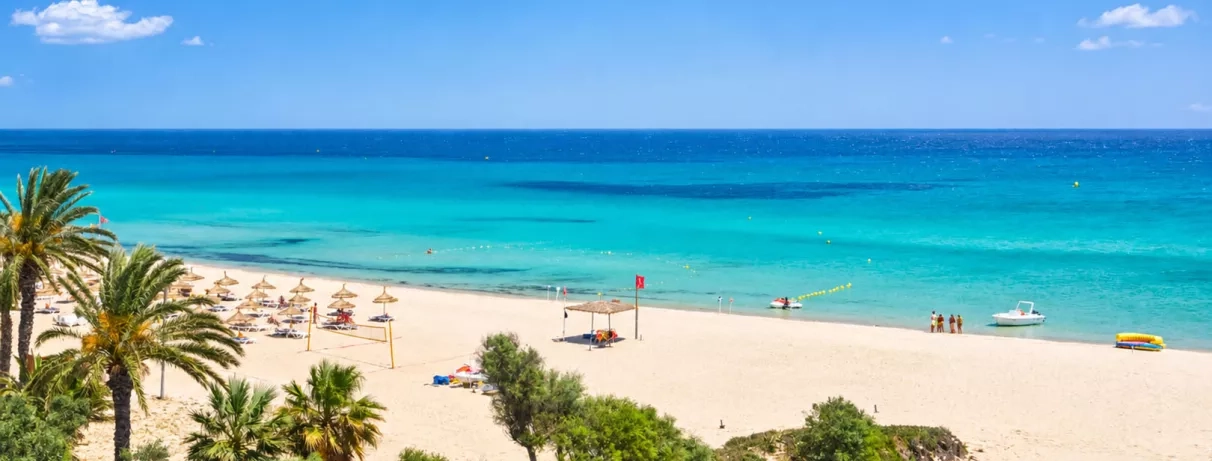 Plage privée de sable fin et eau turquoise du complexe hôtelier Mondi Club Nozha Beach à Hammamet, Tunisie.