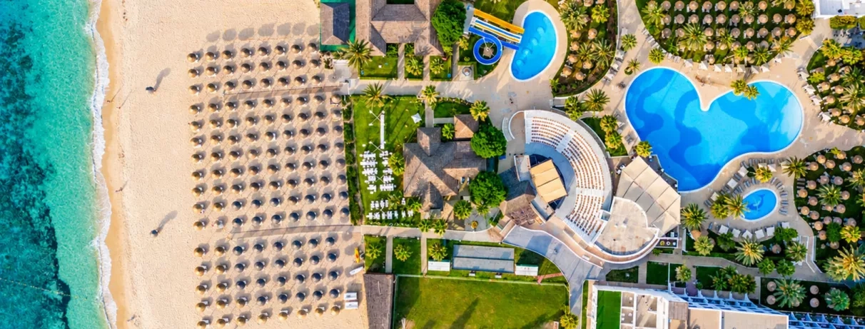 Vue aérienne de l'hôtel Mondi Club Nozha Beach Hammamet montrant les piscines, le parc aquatique, la plage et l'amphithéâtre.