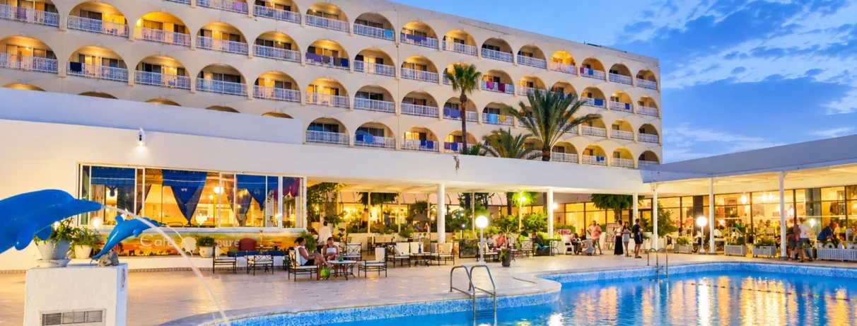 Piscine éclairée et terrasse du restaurant en soirée au Mondi Club One Resort Jockey en Tunisie
