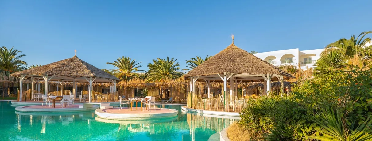 Gazebos en paille et terrasses de détente aménagées autour de la piscine du Mondi Club Shalimar.