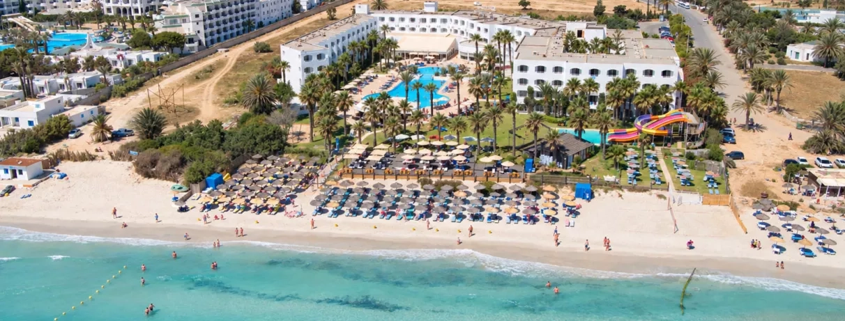 Vue panoramique aérienne de l'hôtel Mondi Club Thalassa Mahdia, de sa plage privée de sable fin et de ses équipements au bord de la mer.