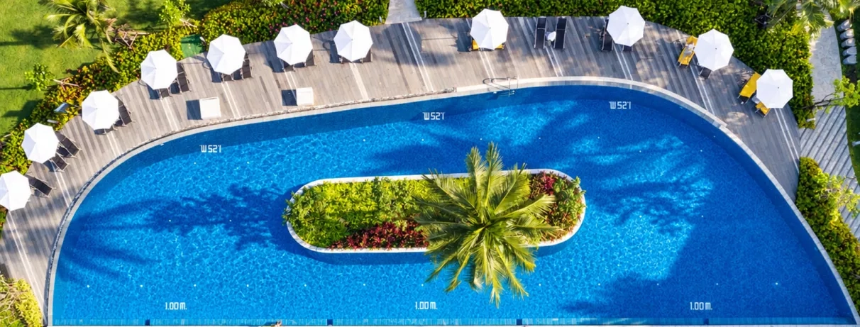 Une vue aérienne d'une piscine avec un îlot central végétalisé.