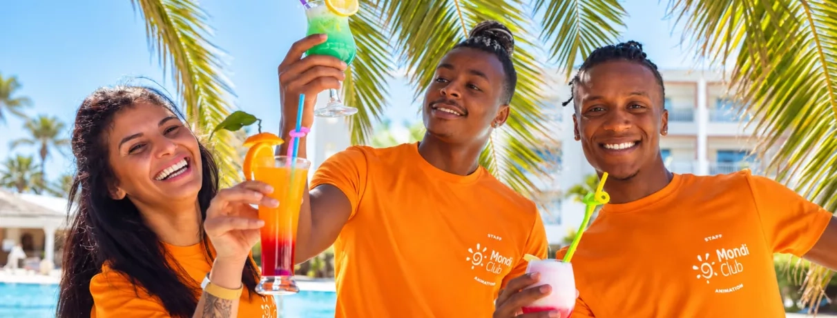 Équipe d'animation Mondi Club Zita Beach souriante avec des cocktails colorés au bord de la piscine.