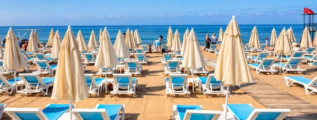 Rangées de transats et parasols sur la vaste plage 