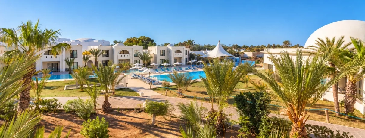 Vue sur les piscines extérieures et l'architecture typique du complexe hôtelier César Thalasso à Djerba.