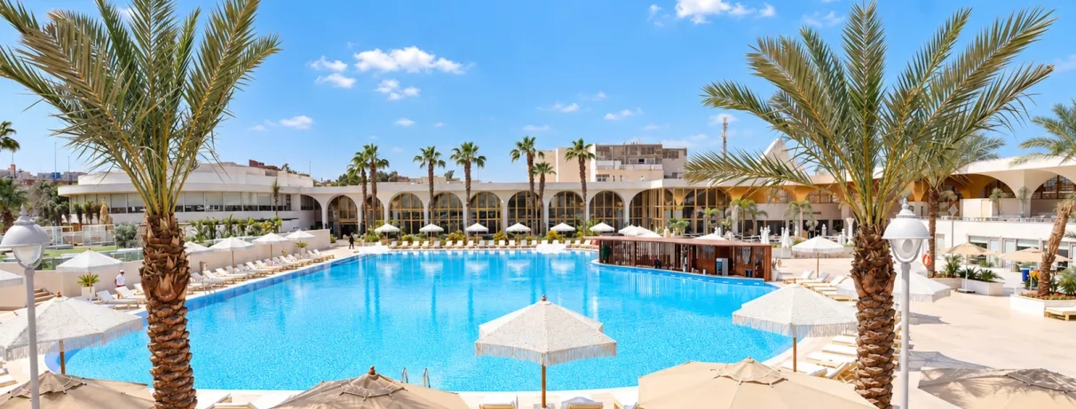 piscine palmiers transats sous un ciel bleu au pyramids park au caire