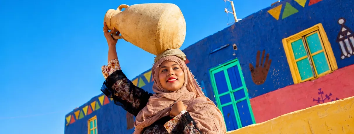 Rencontre authentique avec une femme nubienne près des maisons colorées lors de votre voyage.