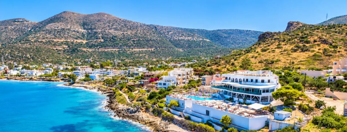 vue aérienne de l'hôtel donnant sur les rochers et la plage, la piscine et le bâtiment